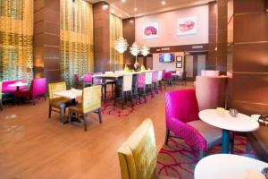a restaurant with tables and chairs and pink chairs at Hampton Inn & Suites La Porte, TX in La Porte