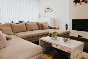 a living room with a couch and a coffee table at Casa Moinho Vedro in Quintiães