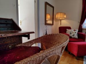 a living room with a wicker chair and a piano at Skogstjärna in Filipstad