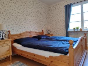 a bedroom with a bed with blue sheets and a window at Mistel in Filipstad