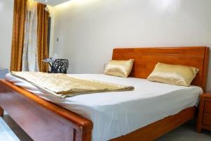 a bed with a wooden headboard in a bedroom at Résidence Madior D1 in Dakar
