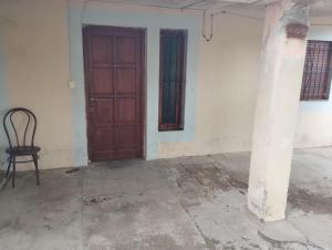 an empty room with a wooden door and a chair at Refugio Pampa - General Pico in General Pico