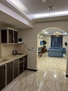 an open kitchen and living room with a blue couch at كاسا للشقق المخدومة 2 in Dammam