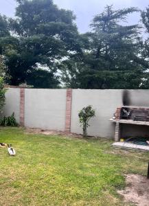 a white fence in a yard with a plant at El rincon del viajero deptos in San Francisco del Monte de Oro