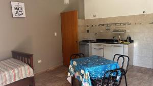 a small kitchen with a table and a table and a table and chairs at El rincon del viajero deptos in San Francisco del Monte de Oro