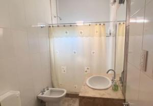 a bathroom with a toilet and a sink and a shower at El rincon del viajero deptos in San Francisco del Monte de Oro