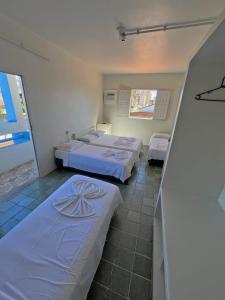 a room with two beds with white sheets at Pousada Valmar in Aracaju