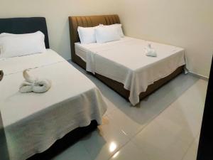 two beds sitting next to each other in a room at A YIE HOMESTAY in Kuantan