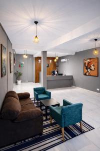a living room with a couch and chairs and a table at Tris Estates Hotel & Suites in Dwarzohn