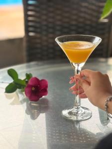 a woman holding a drink on a table at Pumma Hotel Ourilândia in Ourilândia do Norte