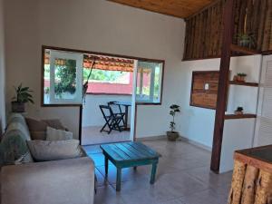 a living room with a couch and a table at Cozy, rustic apartment with balcony in Búzios