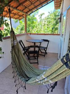 a hammock on the back porch of a house at Cozy, rustic apartment with balcony in Búzios