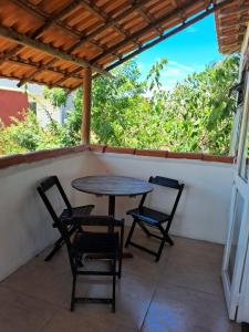 a table and chairs on the porch of a house at Cozy, rustic apartment with balcony in Búzios +11 photos