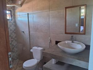 a bathroom with a sink and a toilet and a shower at Cozy, rustic apartment with balcony in Búzios