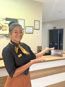 a woman standing in front of a cash register at Pumma Hotel Ourilândia in Ourilândia do Norte +22 photos