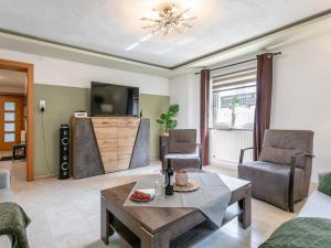 a living room with a table and chairs and a tv at Gästehaus Inntal in Radfeld