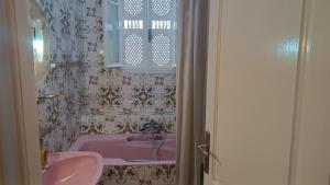 a bathroom with a pink sink and a pink tub at Maison Mira in Bizerte