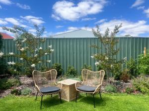 three chairs and a table in a garden at Coastal Calm in Normanville