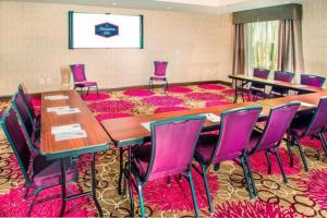 a conference room with a large table and purple chairs at Hampton Inn & Suites La Porte, TX in La Porte