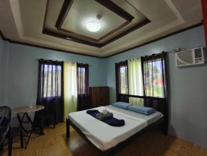 a bedroom with a bed and a table and windows at Daydream Hostel in San Juan