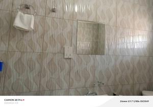 a bathroom with a shower with a mirror and a sink at Raneziah Guesthouse in Kasane +9 photos