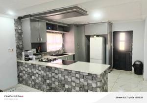a kitchen with a sink and a refrigerator at Raneziah Guesthouse in Kasane