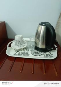 a tea kettle and a cup on a table at Raneziah Guesthouse in Kasane