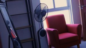 a room with a chair and a fan next to a window at Appartement dépaysante T1B in Tarrafal