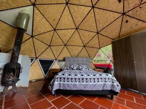 a bedroom with a bed in a room with a wall at Glamping Bosque del Colibri in Guatavita