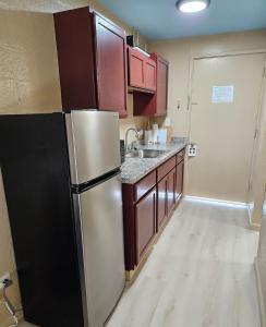 a kitchen with a stainless steel refrigerator and cabinets at Ocean Views • Private Balcony + Prime Location in Hilo