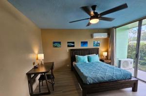 a bedroom with a bed and a ceiling fan at Oceanfront Views • Balcony + Top Hilo Location in Hilo