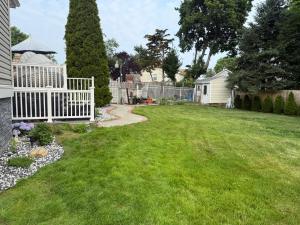 a yard with a white fence and green grass at 2 bedroom Apt in long branch in Long Branch
