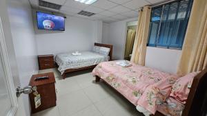 ein Krankenzimmer mit zwei Betten und einem Fenster in der Unterkunft Hostal Ticlio in Cajamarca