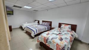 ein Zimmer mit zwei Betten in einem Zimmer in der Unterkunft Hostal Ticlio in Cajamarca