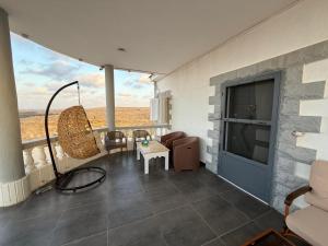 a room with a balcony with a swing and a tv at Duplex Villa 4 rooms in Marsa Matruh