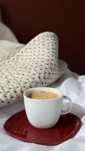 a cup of coffee on a red plate on a bed at Design studio Margherita in Cinisello Balsamo