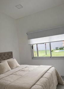 a bedroom with a large bed and a window at Departamento Parque, Asador y Pileta Privada, uso exclusivo in San Luis