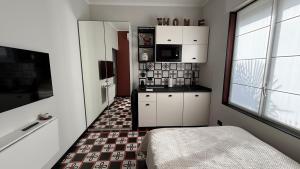 a kitchen with white cabinets and a tile floor at Design studio Margherita in Cinisello Balsamo