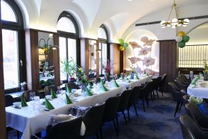 a row of tables and chairs in a room with windows at Hotel de Saxe Leipzig in Leipzig