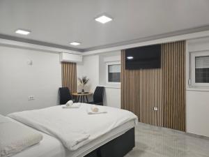 a bedroom with a large bed and a television at Jacuzzi & Sauna Edy room - city center in Zagreb