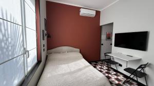 a bedroom with a bed and a desk and a tv at Design studio Margherita in Cinisello Balsamo