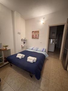 a bedroom with a blue bed with towels on it at Virgy’s House in Sestu