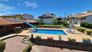 a swimming pool in the backyard of a house at Hostel-Casa25-Meaipe in Guarapari