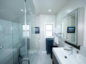 a white bathroom with a shower and a sink at Serene Niagara Inn in Niagara Falls +56 photos