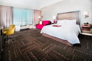 a hotel room with a large bed and a red chair at Hampton Inn & Suites La Porte, TX in La Porte +13 photos