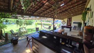 a kitchen and living room with a view of a yard at Hostel-Casa25-Meaipe in Guarapari
