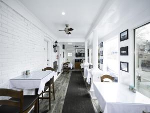 a dining room with white tables and chairs at Serene Niagara Inn in Niagara Falls