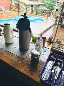 a coffee pot on a counter with a pool in the background at Pousada Lapralapa in Santana do Riacho