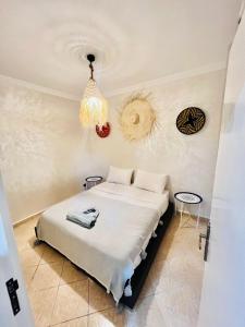 a bedroom with a bed and a chandelier at sun house tamraght in Tamraght Ouzdar