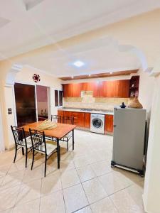 a kitchen with a table and chairs and a refrigerator at sun house tamraght in Tamraght Ouzdar